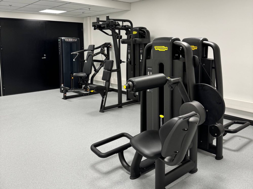 A row of weight-stack strength machines in the building's gym